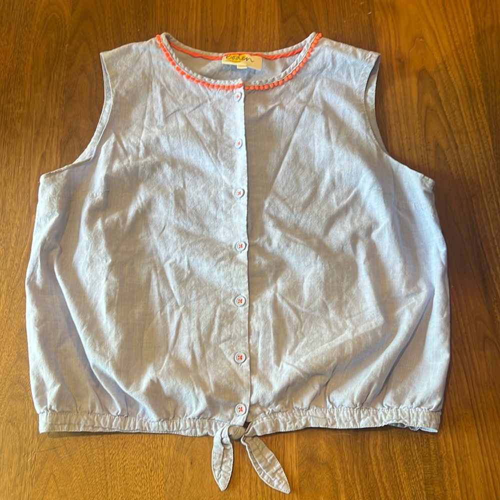 Light blue sleeveless, button-front blouse, tie at bottom.  Coral trim at neck.